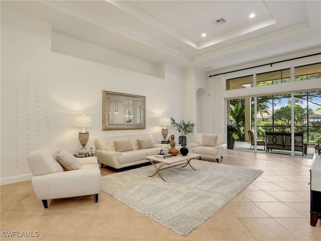 tiled living room with a raised ceiling and a towering ceiling