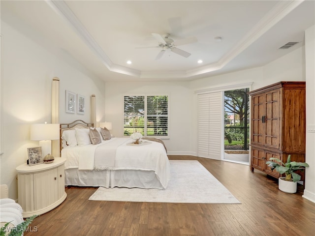 bedroom featuring a raised ceiling, ceiling fan, dark hardwood / wood-style flooring, and crown molding