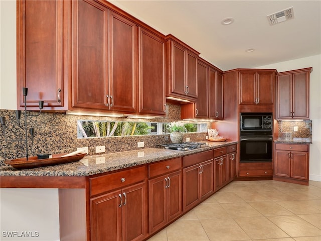 kitchen featuring light tile patterned flooring, decorative backsplash, light stone counters, and black appliances