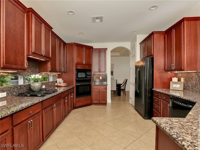 kitchen featuring black appliances, light tile patterned flooring, light stone counters, and backsplash