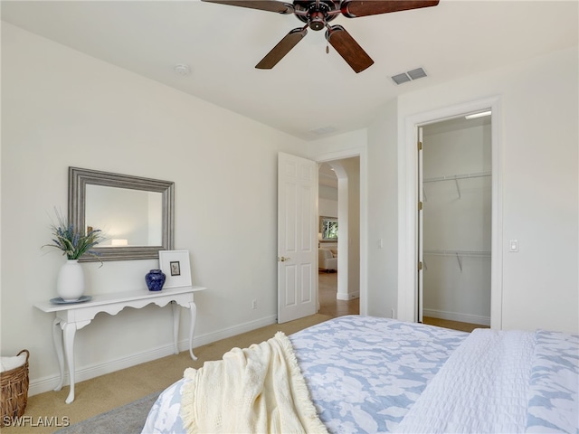 bedroom with a closet, light colored carpet, and ceiling fan