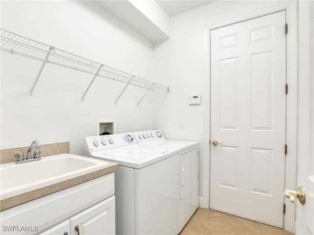 laundry room featuring separate washer and dryer, sink, light tile patterned floors, and cabinets