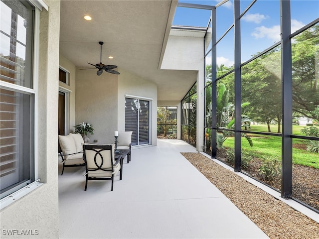 view of patio featuring glass enclosure and ceiling fan