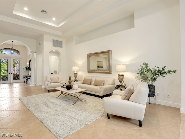 tiled living room featuring a raised ceiling and french doors