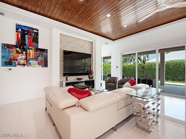 living room with a raised ceiling, light tile patterned floors, and wooden ceiling