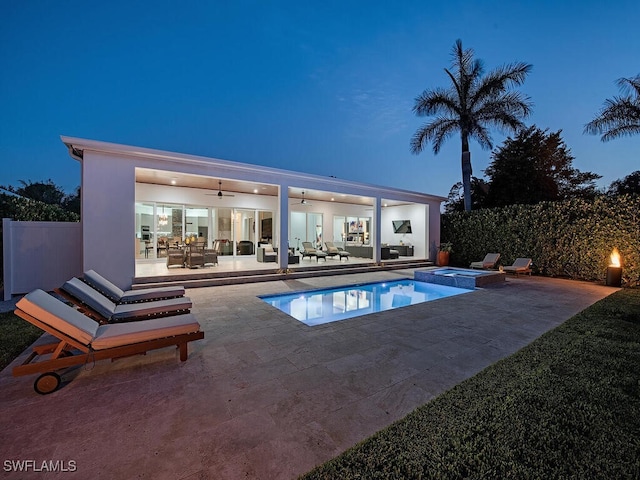 pool at dusk with an outdoor hangout area, an in ground hot tub, ceiling fan, and a patio area