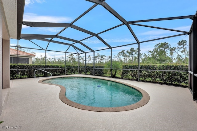 view of pool featuring glass enclosure and a patio area