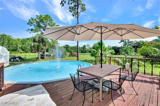 view of swimming pool featuring a wooden deck and a yard