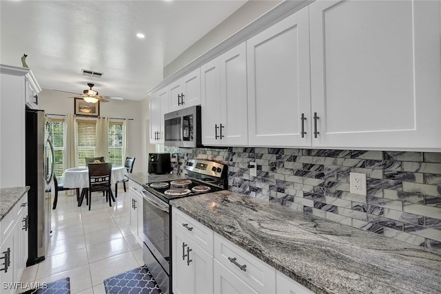 kitchen with stone counters, ceiling fan, white cabinetry, backsplash, and stainless steel appliances