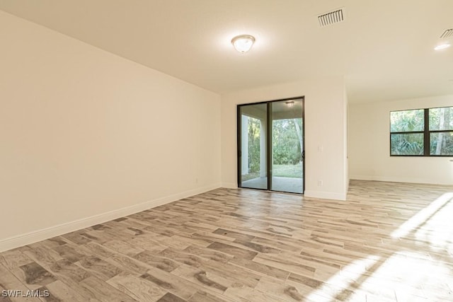 empty room featuring a wealth of natural light and light hardwood / wood-style flooring