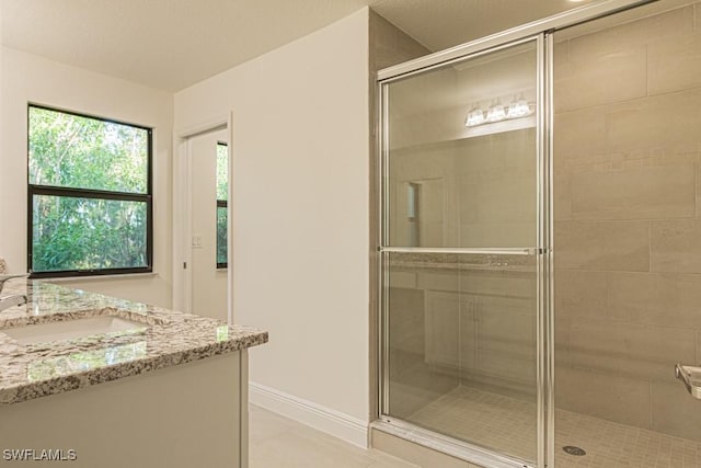 bathroom featuring vanity, tile patterned floors, and walk in shower