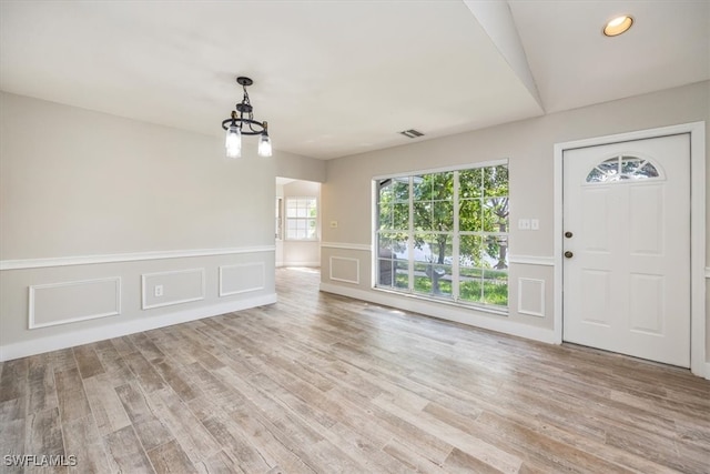 entryway with an inviting chandelier and light wood-type flooring