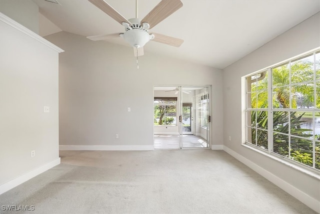 carpeted empty room featuring ceiling fan, a healthy amount of sunlight, and vaulted ceiling