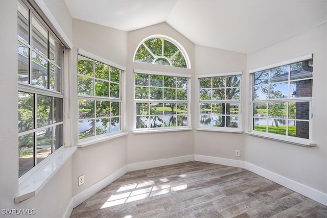 unfurnished sunroom featuring a water view and lofted ceiling