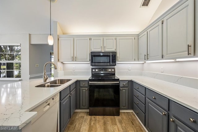 kitchen with hanging light fixtures, appliances with stainless steel finishes, hardwood / wood-style flooring, gray cabinets, and sink