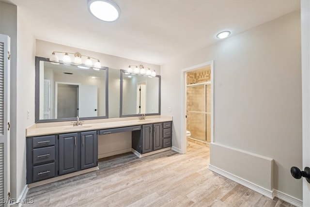 bathroom with vanity, a shower with shower door, wood-type flooring, and toilet