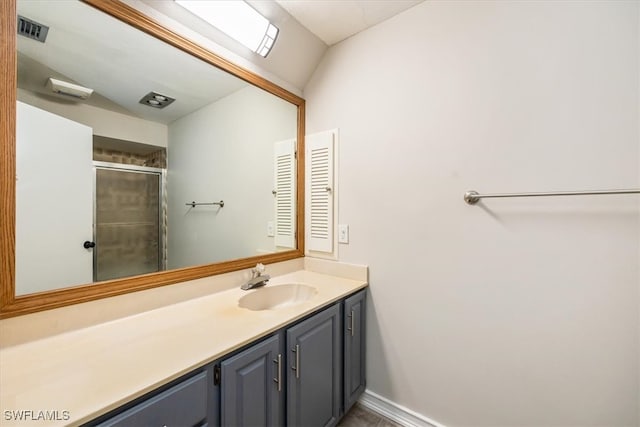 bathroom with a shower with door, vanity, and lofted ceiling