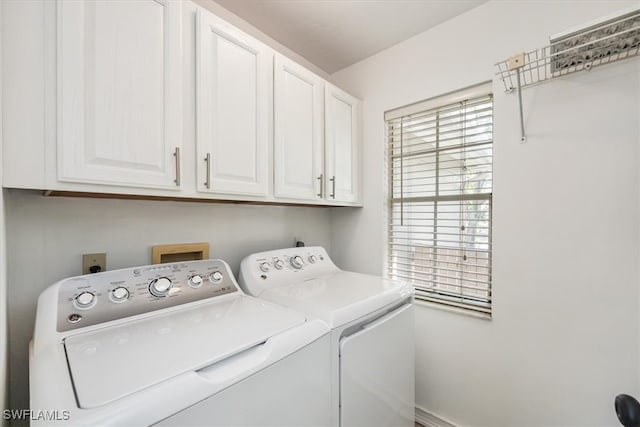 laundry area with independent washer and dryer and cabinets