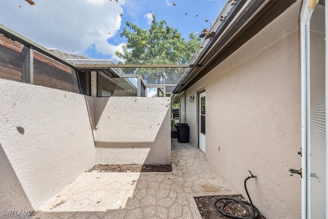 view of patio with glass enclosure