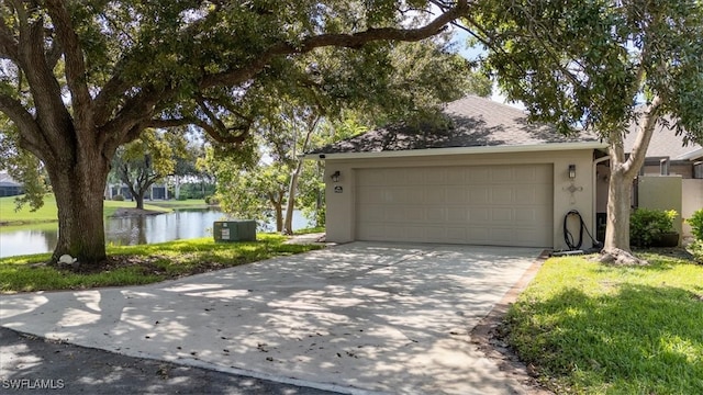 garage featuring a lawn and a water view