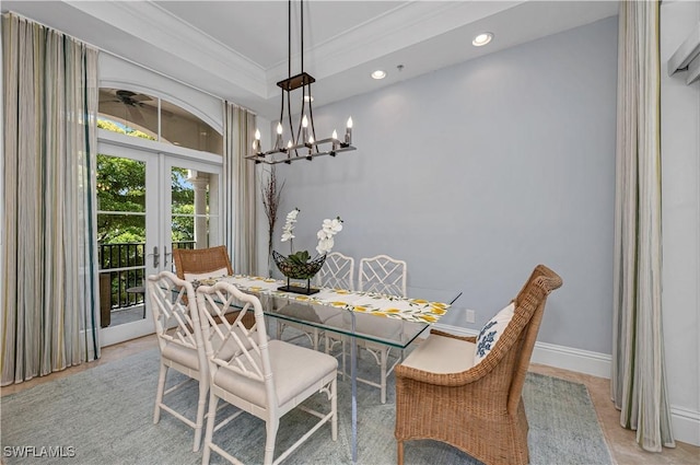 dining area with an inviting chandelier, french doors, and crown molding