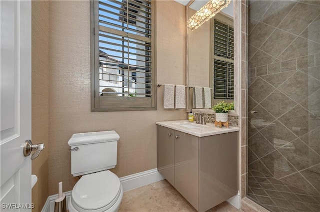 bathroom featuring vanity, a tile shower, and toilet