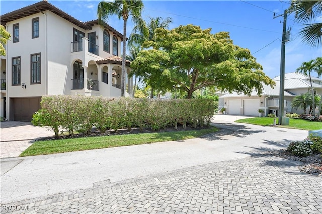 view of front of property with a garage and a balcony