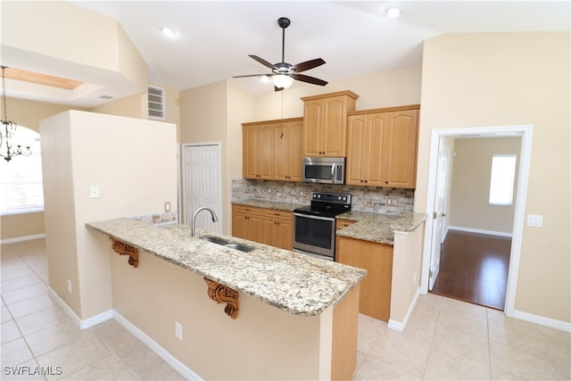 kitchen featuring hanging light fixtures, appliances with stainless steel finishes, light tile patterned floors, and sink