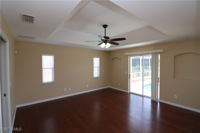 spare room featuring a tray ceiling, hardwood / wood-style floors, and ceiling fan