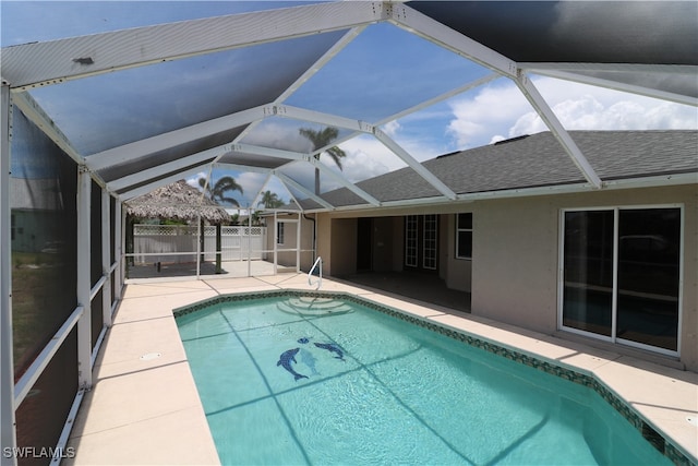 view of swimming pool featuring a patio and glass enclosure