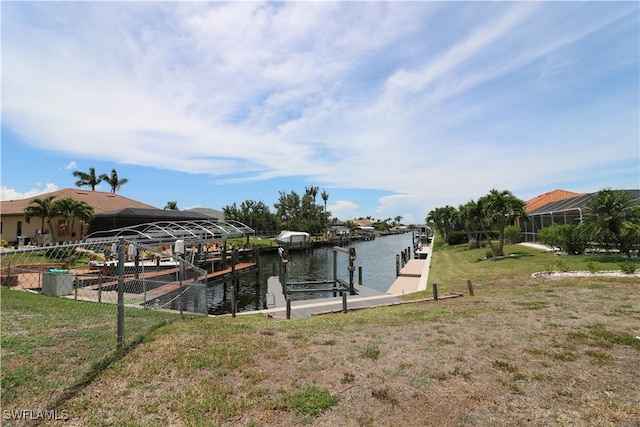 view of dock with a yard and a water view