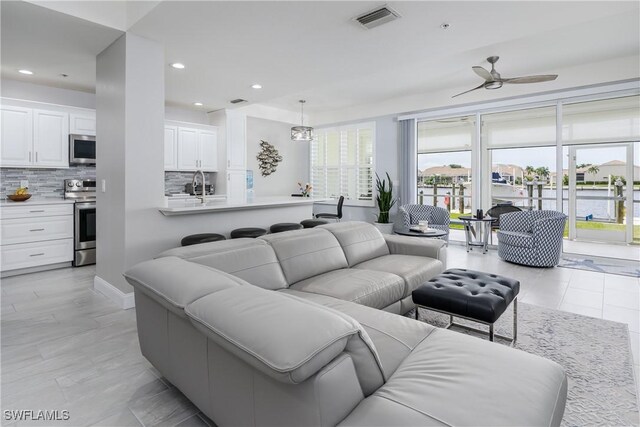 living room featuring ceiling fan, a wealth of natural light, and light tile patterned floors