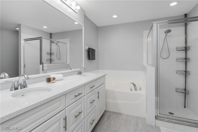 bathroom with a garden tub, a sink, a shower stall, and double vanity