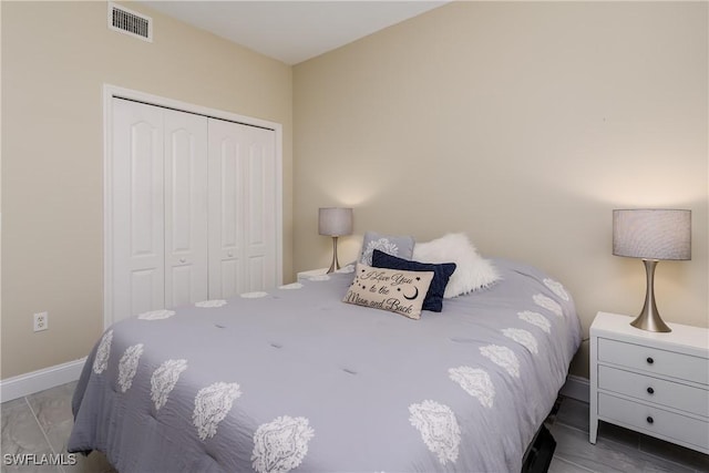 bedroom with a closet, visible vents, and baseboards