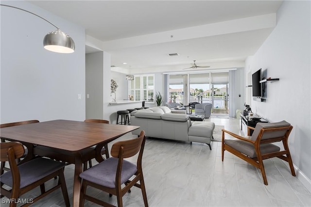 dining space featuring a ceiling fan and baseboards