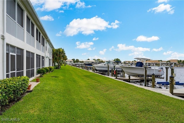 dock area featuring a lawn and boat lift