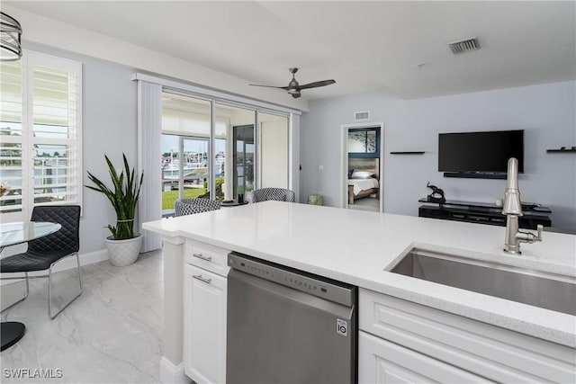 kitchen with a wealth of natural light, visible vents, stainless steel dishwasher, white cabinetry, and a sink