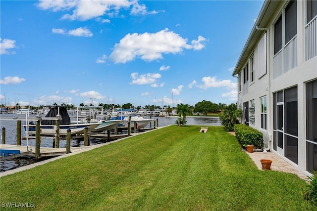 view of dock featuring a water view, a yard, and boat lift