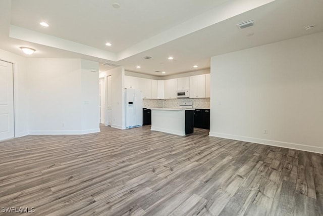 unfurnished living room with light hardwood / wood-style flooring and sink