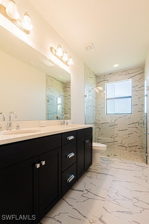 bathroom with vanity, toilet, and a shower with door