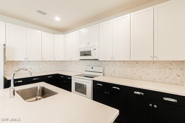 kitchen with tasteful backsplash, sink, white cabinets, and white appliances