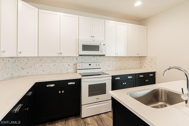 kitchen with white cabinetry, white appliances, and sink