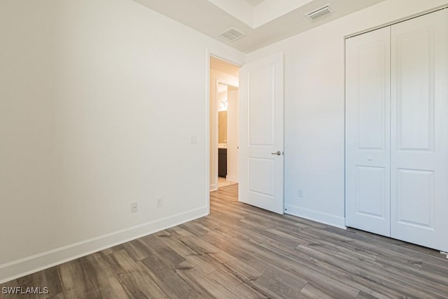 unfurnished bedroom with wood-type flooring and a closet