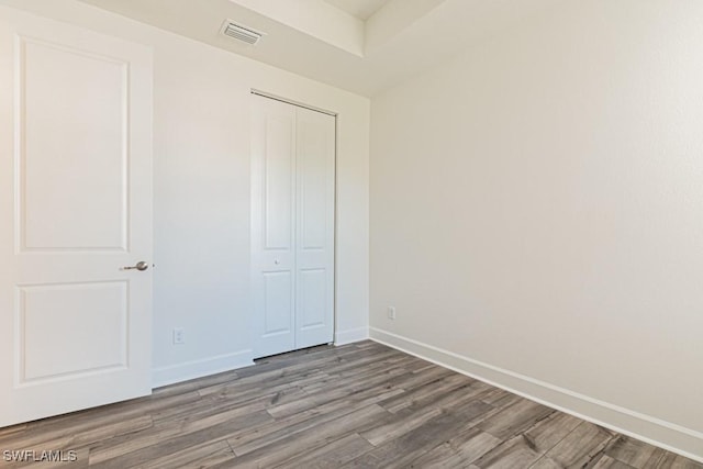 unfurnished bedroom featuring hardwood / wood-style floors and a closet