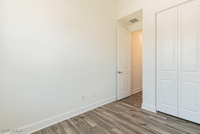 unfurnished bedroom with a closet and hardwood / wood-style flooring