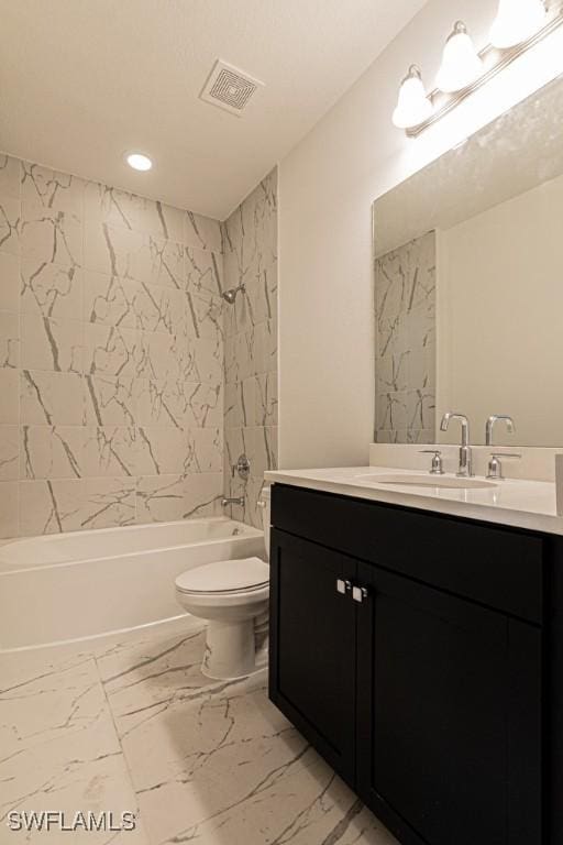 full bathroom featuring toilet, vanity, and tiled shower / bath