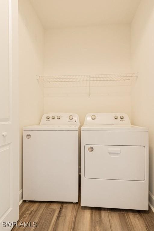 laundry area with hardwood / wood-style flooring and washer and dryer