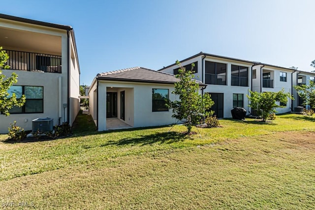 rear view of property with a yard and cooling unit