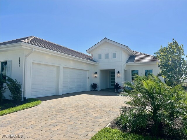 view of front facade with a garage, decorative driveway, and a tile roof