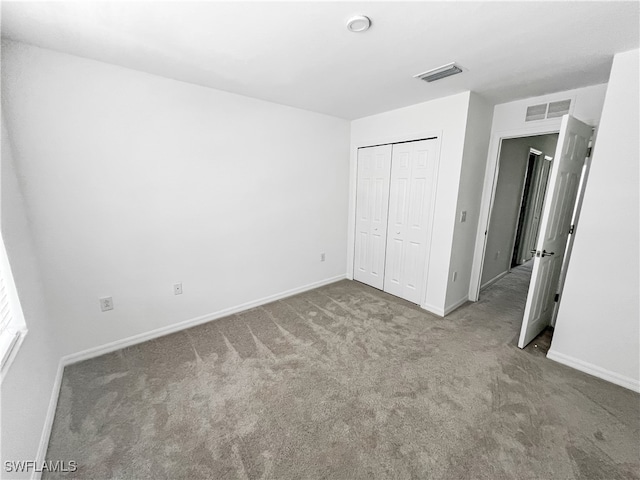 unfurnished bedroom with carpet flooring and a closet